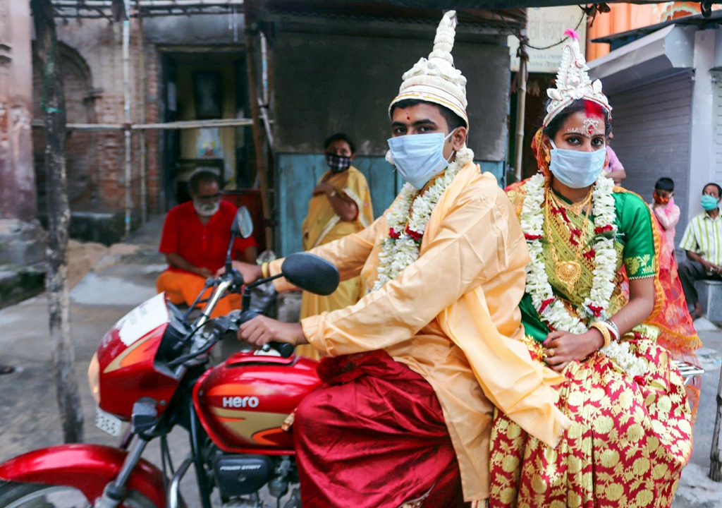 Burdwan: A newly married couple rides a bike after performing rituals at Sarbamangala Mandir, during the ongoing COVID-19 lockdown, in Burdwan district, Sunday, May 31, 2020. (PTI Photo)(PTI31-05-2020 000233B)
