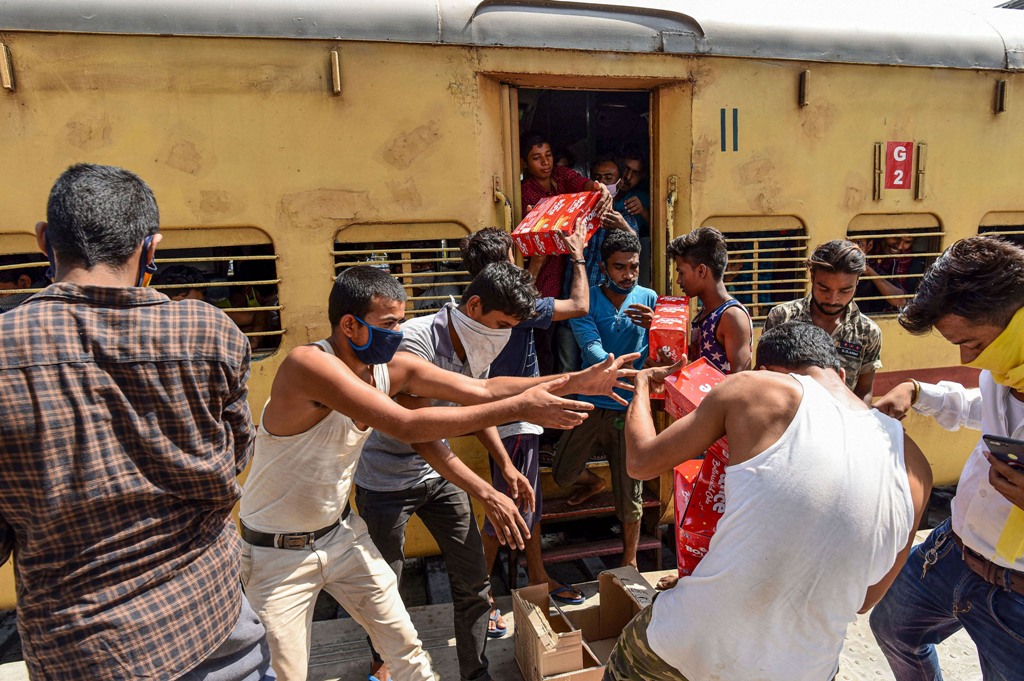 Allahabad: A group of migrants engage in a scuffle for packets of free food and water bottles distributed by railway officials during ongoing COVID-19 lockdown, at the railway station in Allahabad, Monday, June 1, 2020. (PTI Photo)(PTI01-06-2020 000217B)(PTI01-06-2020 000317B)