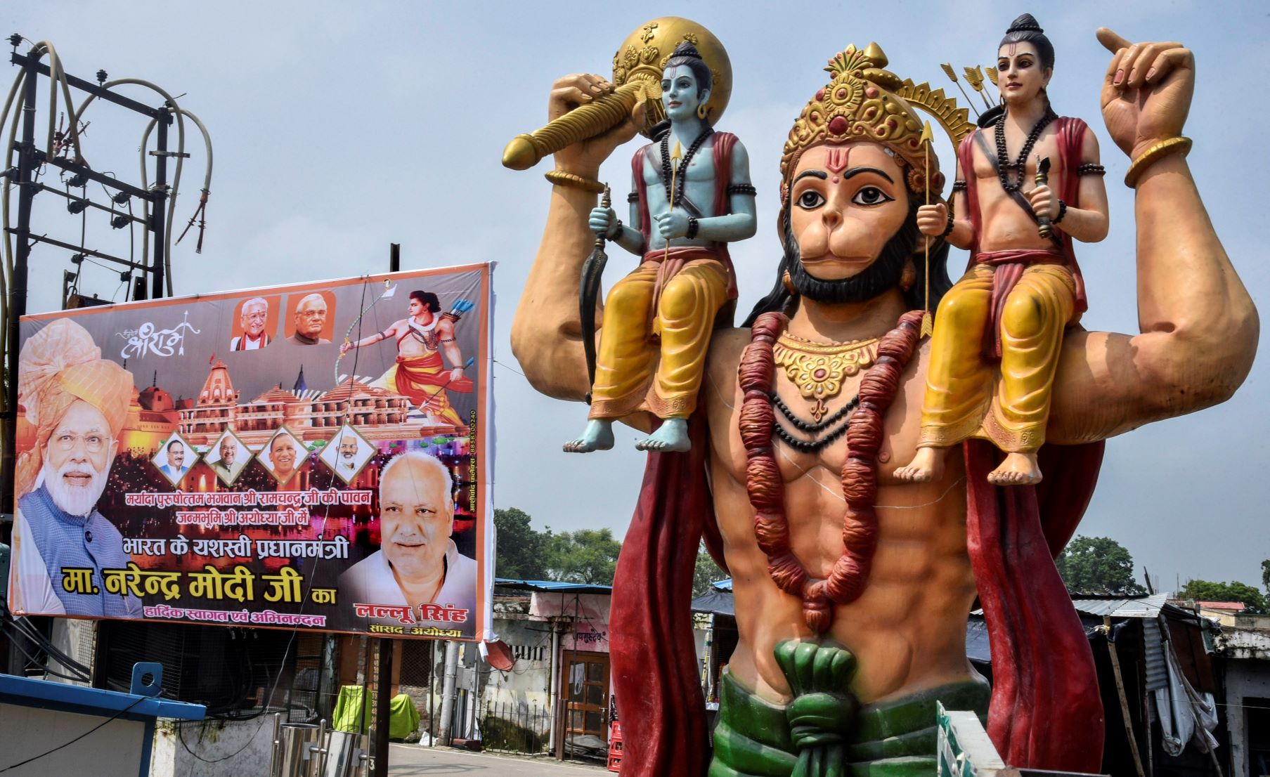 Ayodhya: A hoarding of PM Narendra Modi and other leaders put up beside a statue of Lord Hanuman, ahead of the foundation laying ceremony of Ram Temple, in Ayodhya, Thursday, July 30, 2020. (PTI Photo)(PTI30-07-2020 000044B)