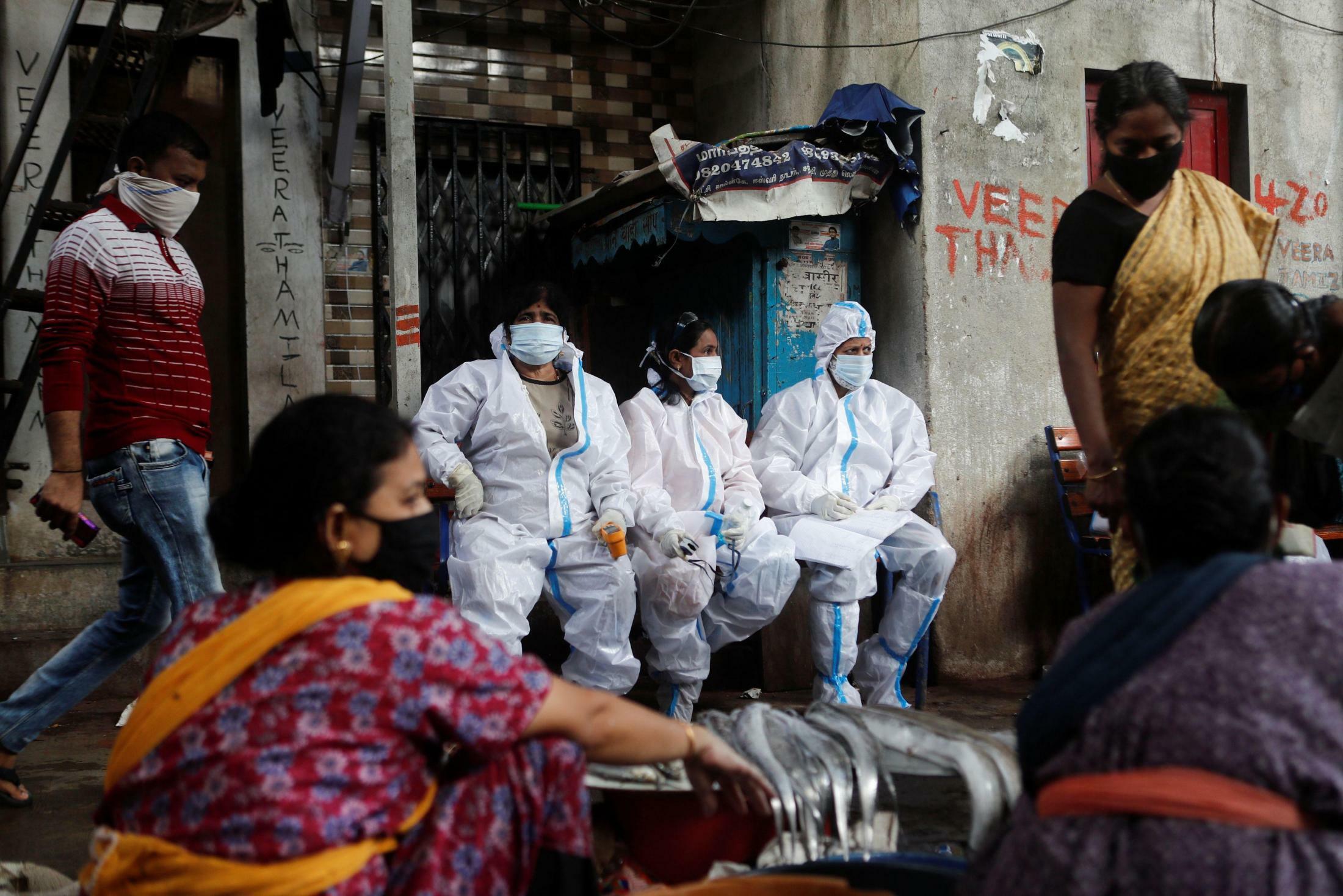 Health workers in personal protective equipment rest during a check up campaign for the coronavirus disease (COVID-19) at a slum area in Mumbai, India, August 3, 2020. REUTERS/Francis MascarenhasREUTERS
