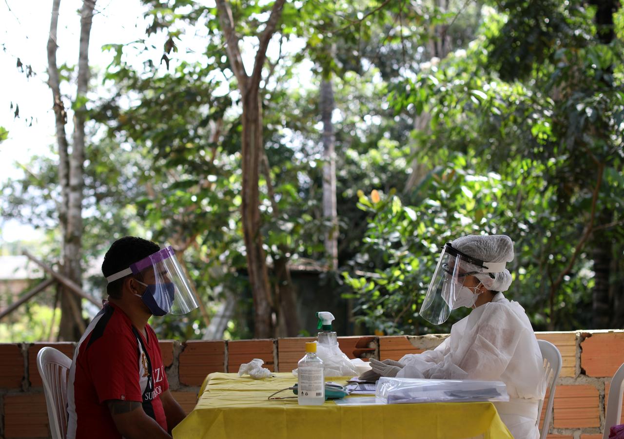 A health worker talks with a man before testing for the coronavirus disease (COVID-19), in the Bela Vista do Jaraqui, in the Conservation Unit Puranga Conquista along the Negro River banks, where Ribeirinhos (forest dwellers) live, amid the coronavirus disease (COVID-19) outbreak, in Manaus, Brazil, May 29, 2020. REUTERS/Bruno Kelly