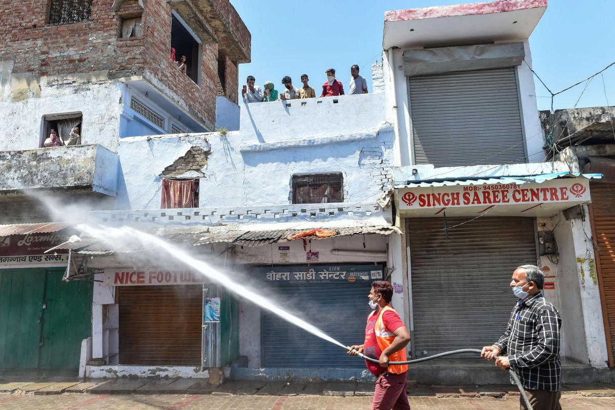 Nagar Nigam workers sanitize an area sealed to contain the spread of COVID-19, in Lucknow, Thursday, April 9, 2020. | Photo Credit: PTI