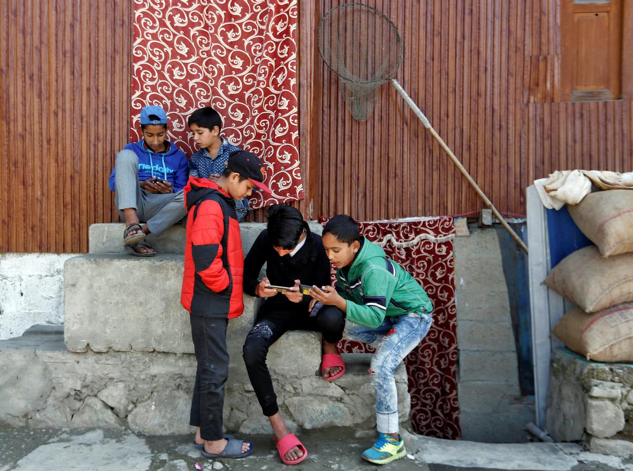 FILE PHOTO: Children play games on their mobile phones in a neighbourhood in Srinagar October 10, 2019. REUTERS/Danish Ismail