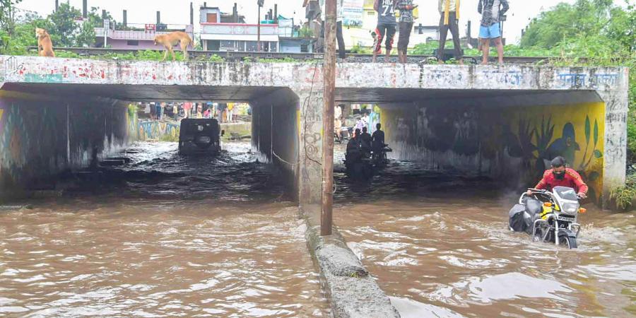 Commuters move through a waterlogged underpass after heavy rainfall in Bhopal Saturday Aug 29 2020. (Photo | PTI)