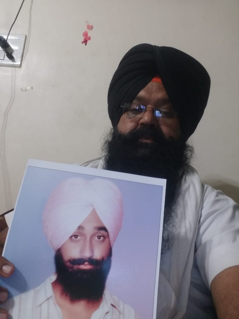 गुरमीत सिंह की तस्वीर दिखाते उनके भाई रंजीत सिंह.