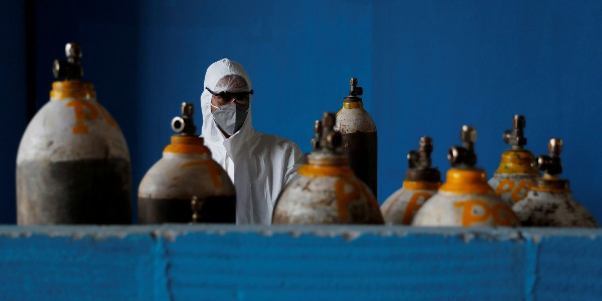 A medical worker stands next to an oxygen cylinder at the Yatharth Hospital in Noida, on the outskirts of New Delhi, India, September 15, 2020. Photo: Reuters/Adnan Abidi