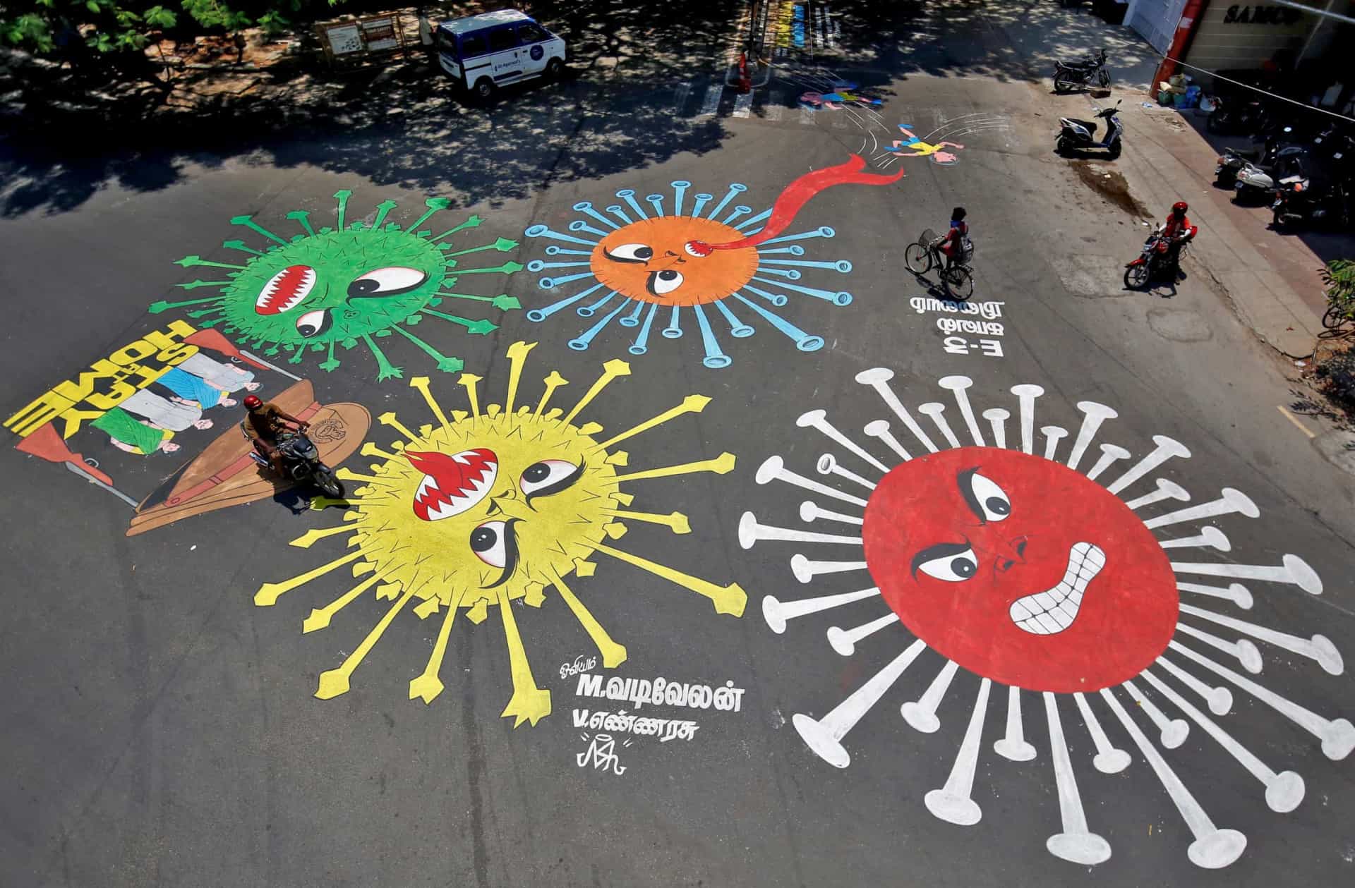 People move past graffiti on a road depicting the coronavirus as an attempt to raise awareness about the importance of staying at home during a 21-day nationwide lockdown to slow the spreading of the coronavirus disease (COVID-19), in Chennai, April 13, 2020. REUTERS/P. Ravikumar