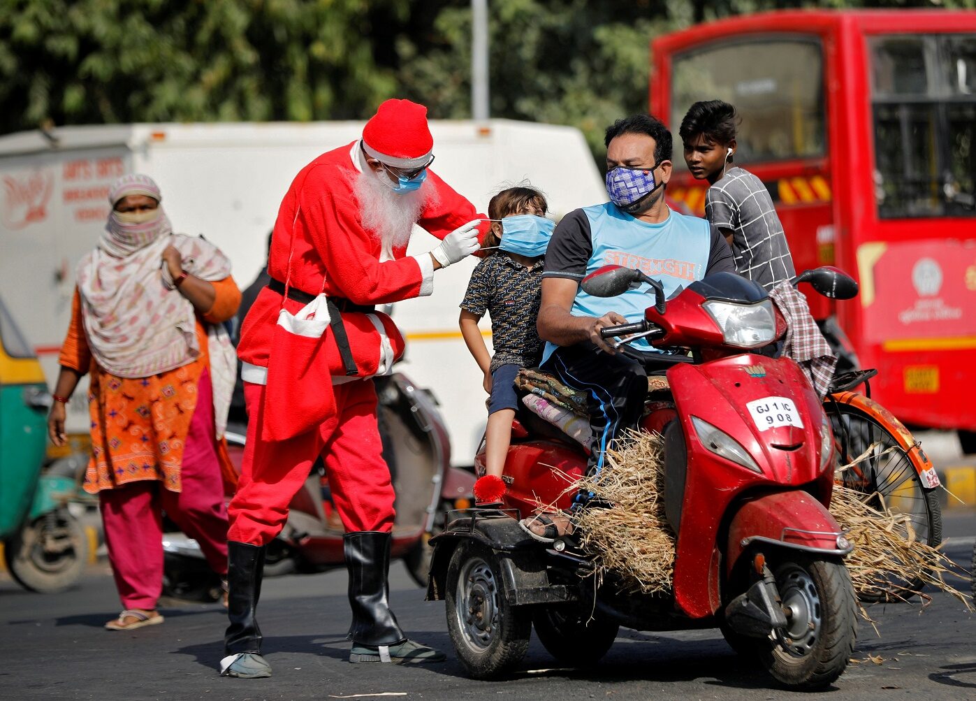 A man wearing a Santa Claus costume distributes free masks on an intersection, amidst the spread of the coronavirus disease (COVID-19), in Ahmedabad, India, December 18, 2020. REUTERS/Amit Dave