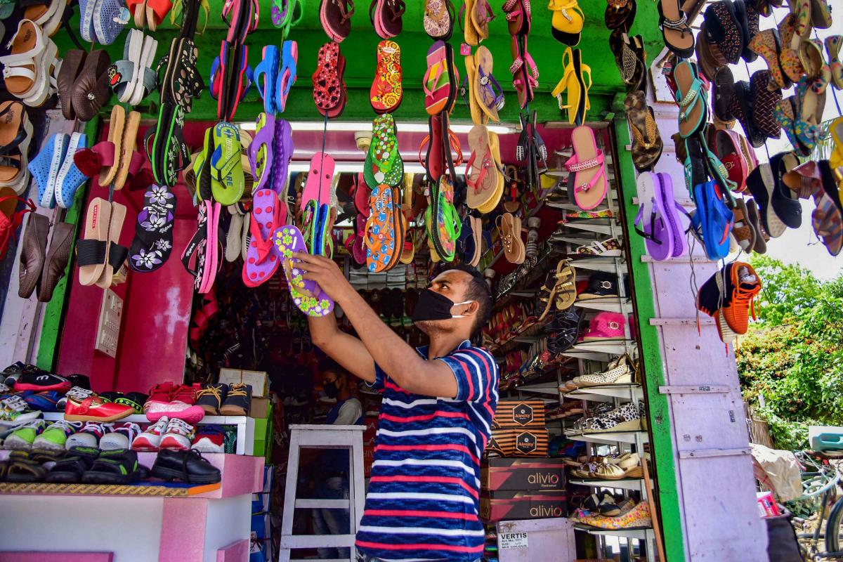A shopkeeper arranges shoes at his store as he waits for customers after authorities eased restrictions during the ongoing COVID-19 nationwide lockdown in Nagaon district, Assam May 4 2020. (Photo | PTI)