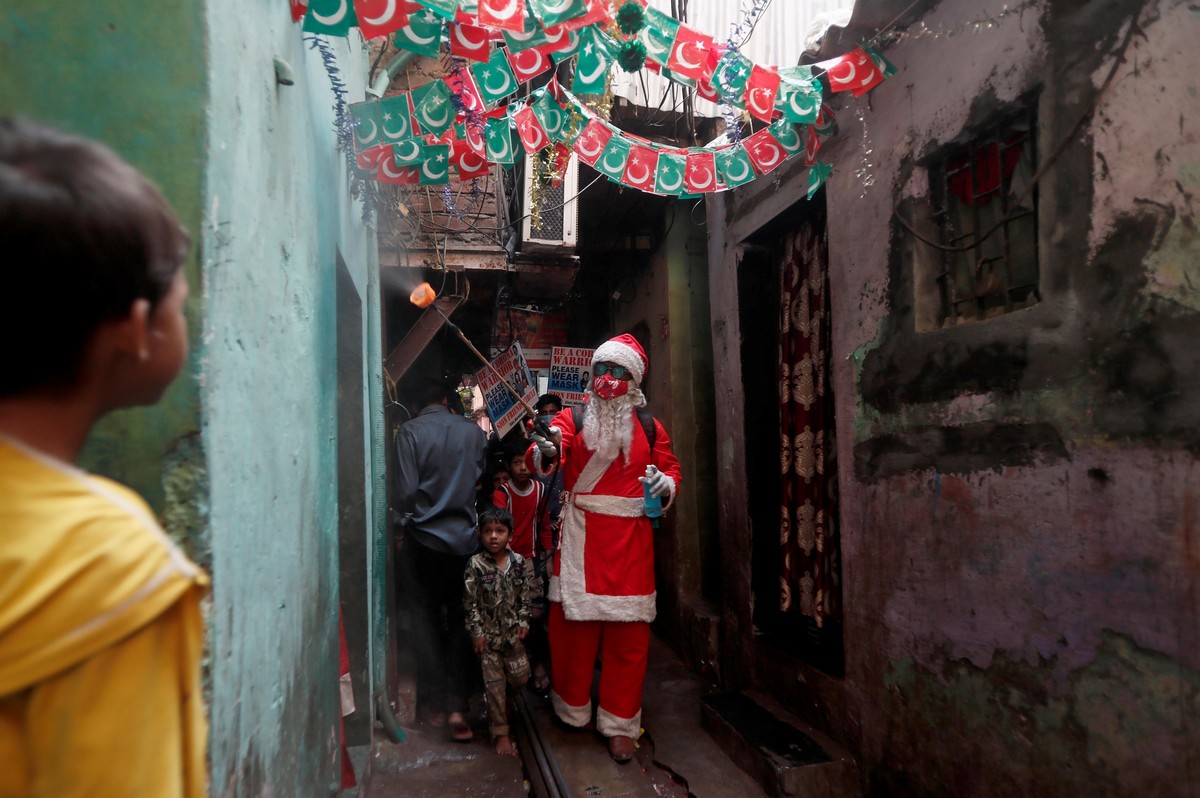 A man wearing a Santa Claus costume sanitizes the entrance of a house inside a slum, amidst the spread of the coronavirus disease (COVID-19), in Mumbai, India, December 19, 2020. (Photo by Francis Mascarenhas/Reuters)