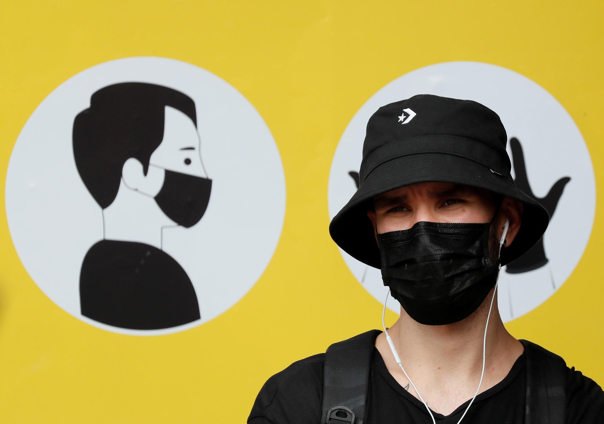 A man wearing a protective face mask amid the outbreak of the coronavirus disease (COVID-19) stands in front of a social poster in central Kyiv, Ukraine July 30, 2020. REUTERS/Gleb Garanich/File Photo