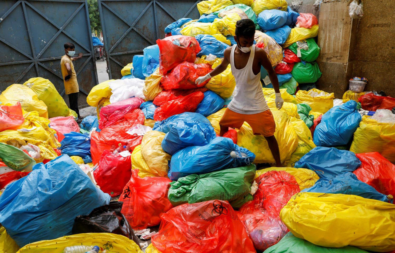 दिल्ली के एक अस्पताल से मेडिकल कचरा निकालता एक कर्मचारी. (फोटो: (फोटो: रॉयटर्स/अदनान आबिदी)