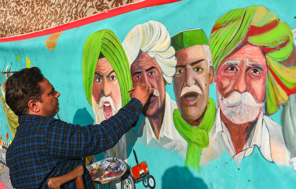 सिंघु बॉर्डर पर किसानों की पेंटिंग बनाता कलाकार. (फोटो: पीटीआई)