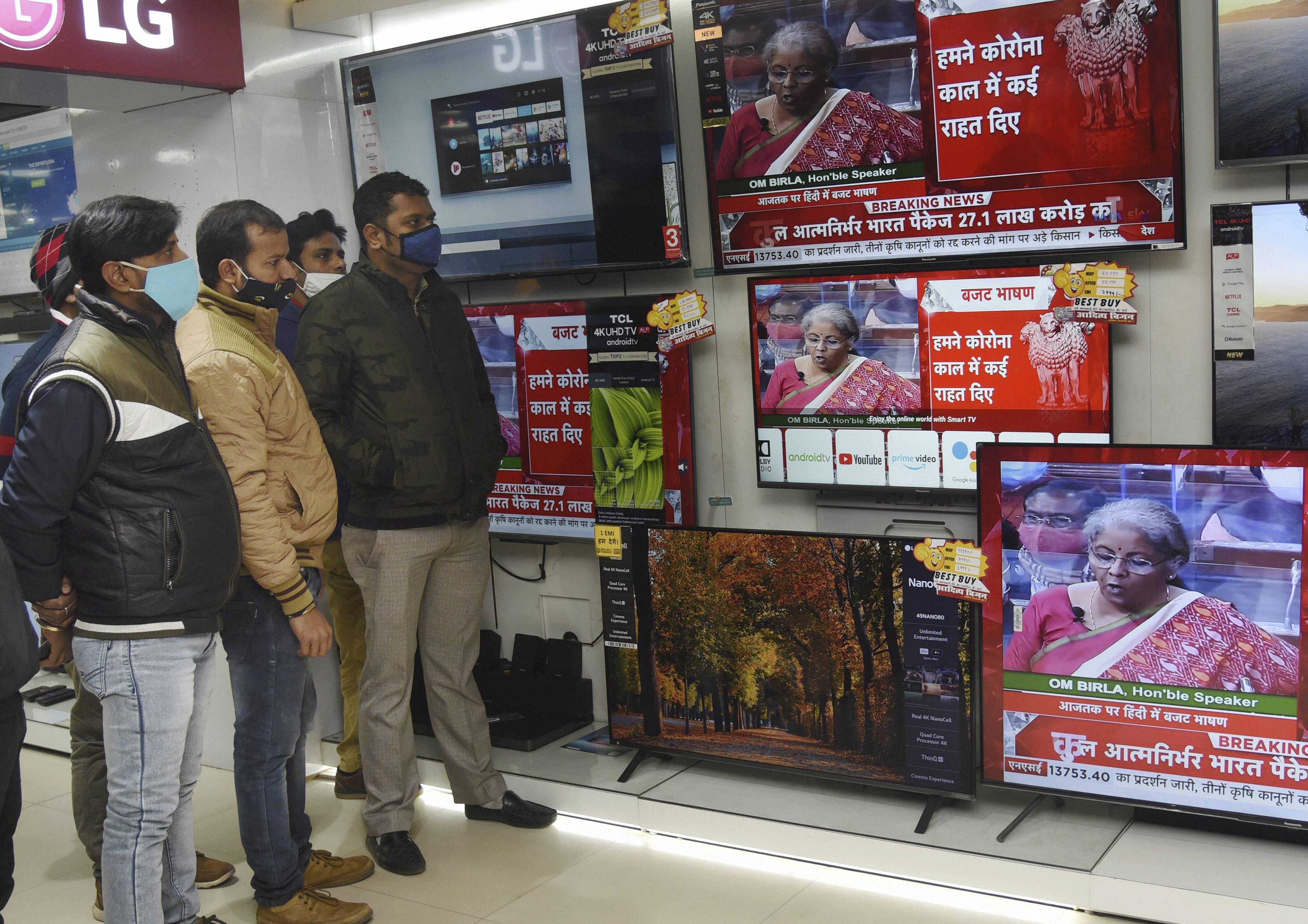Patna: People watch Finance Minister Nirmala Sitharaman present the Union Budget 2021-21 on television sets, during the Budget Session of Parliament, at an electronics store in Patna, Monday, Feb, 1, 2021. (PTI Photo)(PTI02_01_2021_000061B)