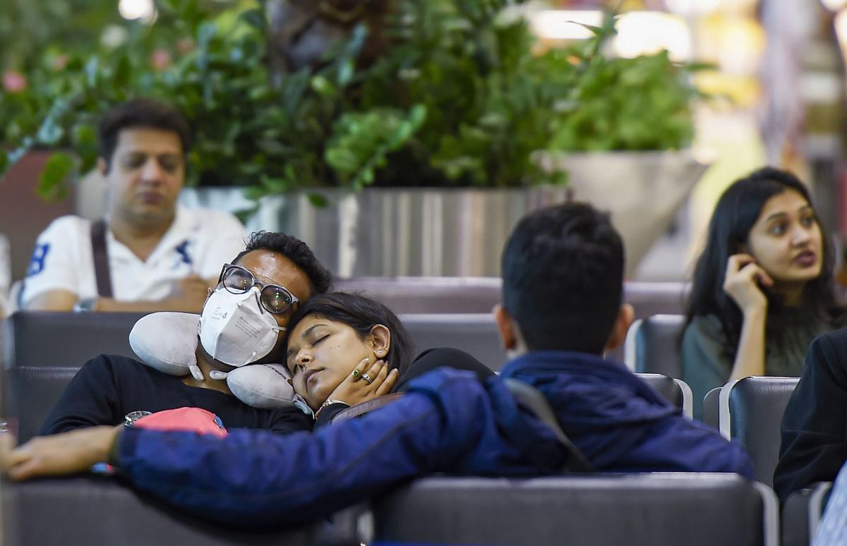 A man wearing a mask as part of preventive measures for the deadly coronavirus, takes a nap at an airport in Mumbai, Saturday, Feb. 22, 2020. (PTI Photo)