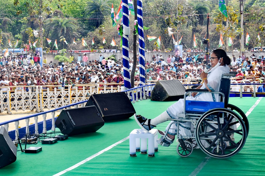 Bankura: West Bengal CM and TMC supremo Mamata Banerjee, sitting on a wheel-chair, addresses an election campaign rally ahead of state assembly polls, in Bankura, Tuesday, March 16, 2021. (PTI Photo)(PTI03 16 2021 000071B)