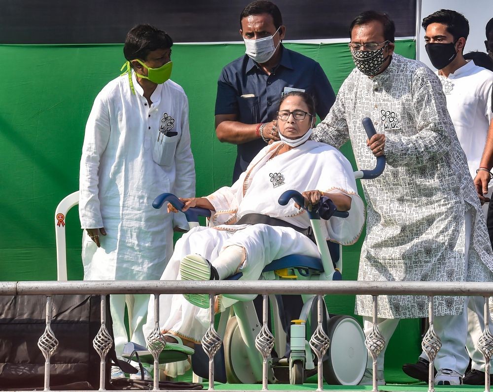 Kolkata: TMC leader Aroop Biswas pulls the wheelchair of WB CM and TMC Supremo Mamata Banerjee during 'Nandigram Diwas'rally at Hazra crossing from Gandhi Statue, in Kolkata, Sunday, March 14, 2021. (PTI Photo/Swapan Mahapatra)