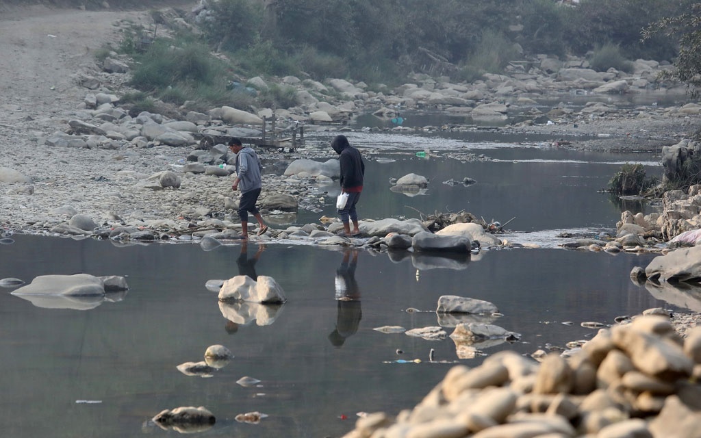 मिजोरम के सीमाई जिले चम्पाई के एक गांव में टीओ नदी पार करते लोग. (फोटो: रॉयटर्स)