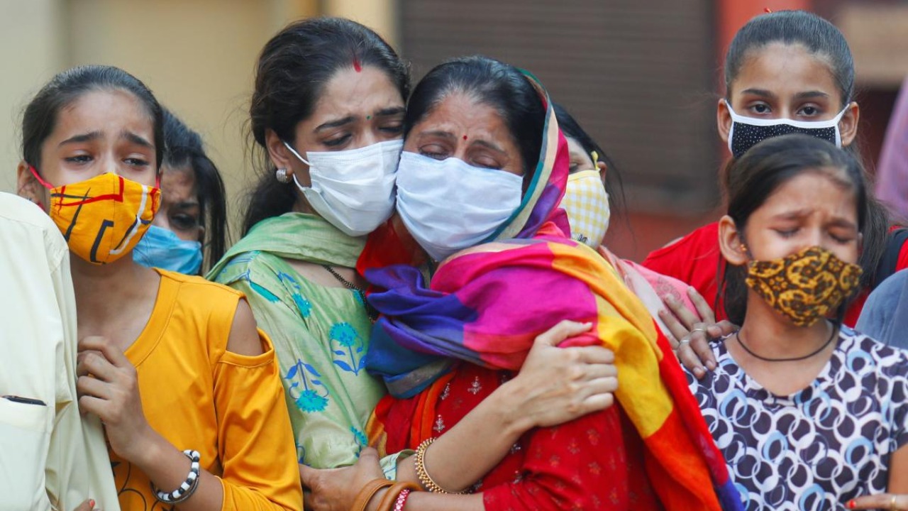 कोरोना संक्रमित व्यक्ति की मौत के बाद दिल्ली के एक शवदाह गृह में शोक संतप्त परिजन. (फोटो: रॉयटर्स)