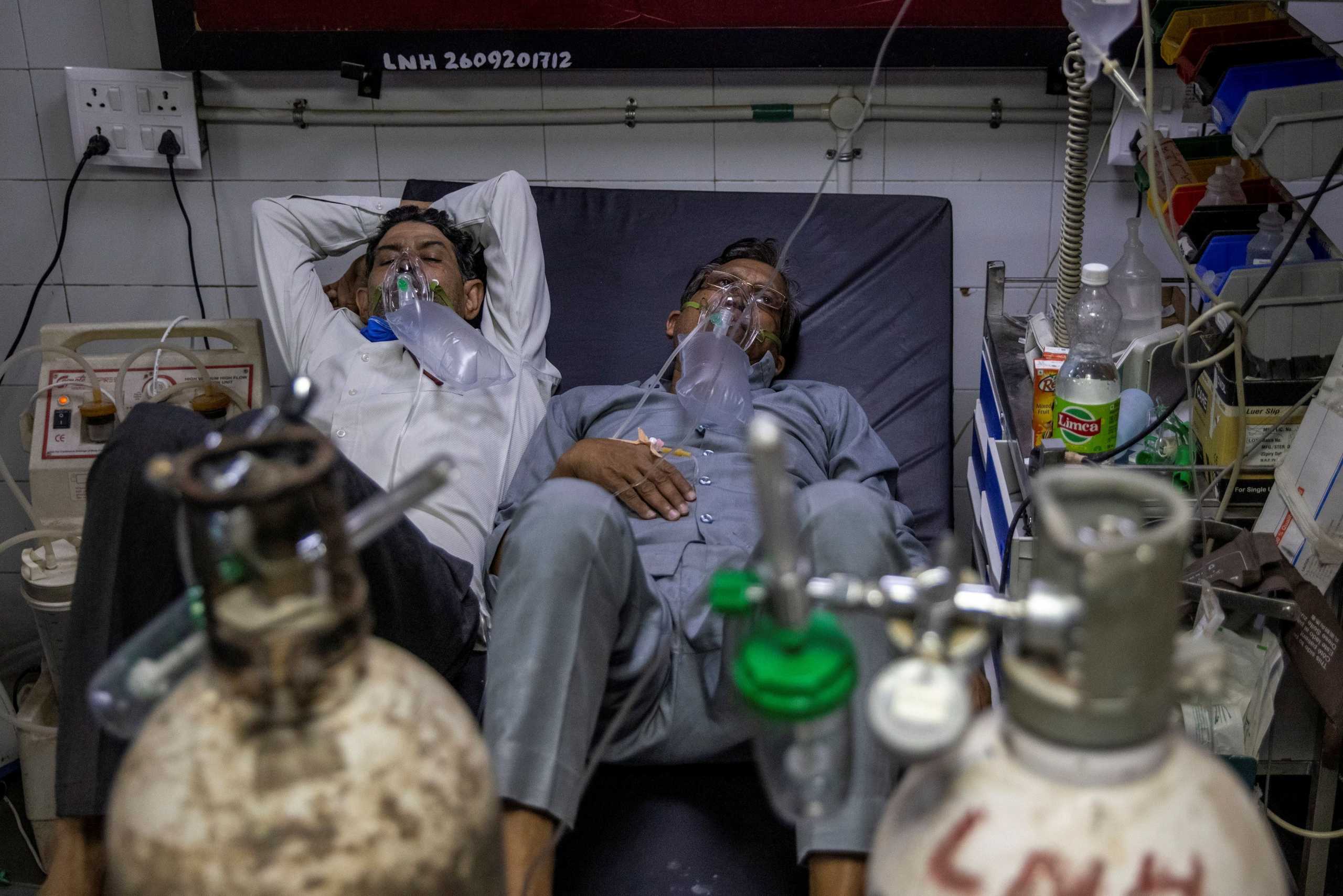 दिल्ली के जयप्रकाश नारायण अस्पताल के एक वार्ड में एक ही बेड पर लेटे कोरोना संक्रमित दो लोग. (फोटो: रॉयटर्स)