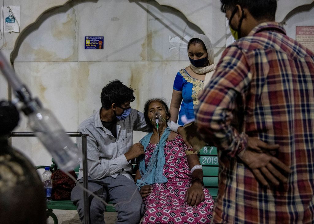उत्तर प्रदेश के गाजियाबाद शहर के एक गुरुद्वारा में कोविड-19 महामारी के बीच सांस में तकलीफ बाद ऑक्सीजन के सहारे एक महिला. (फोटो: रॉयटर्स)