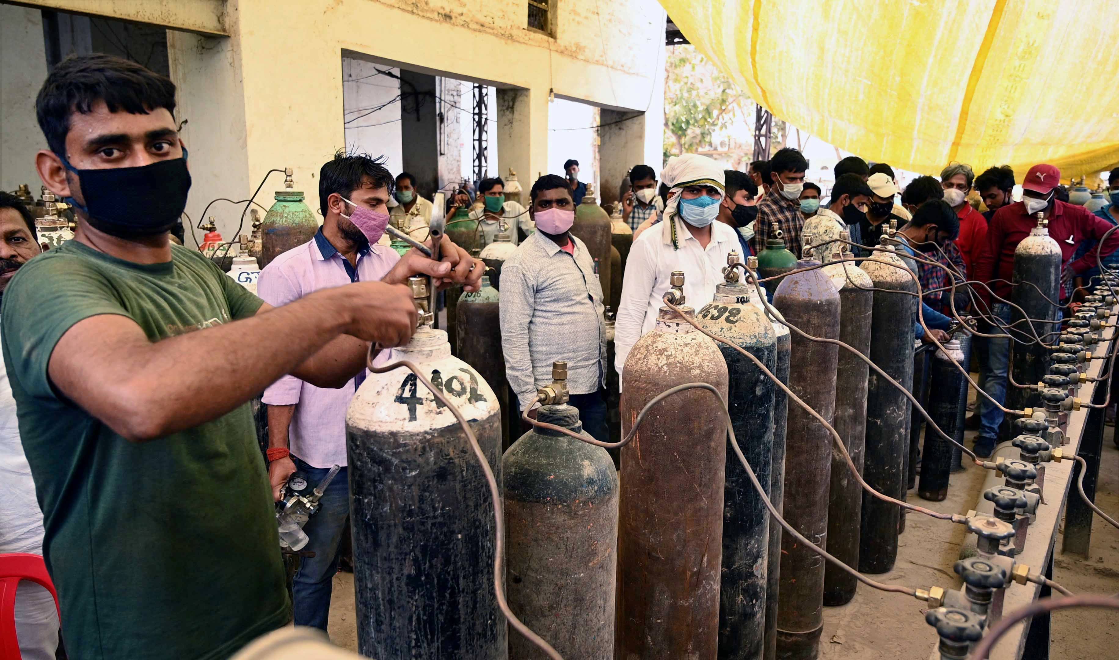 इलाहाबाद के एक प्लांट में ऑक्सीजन की लाइन में लगे मरीजों के परिजन. (फोटो: पीटीआई)