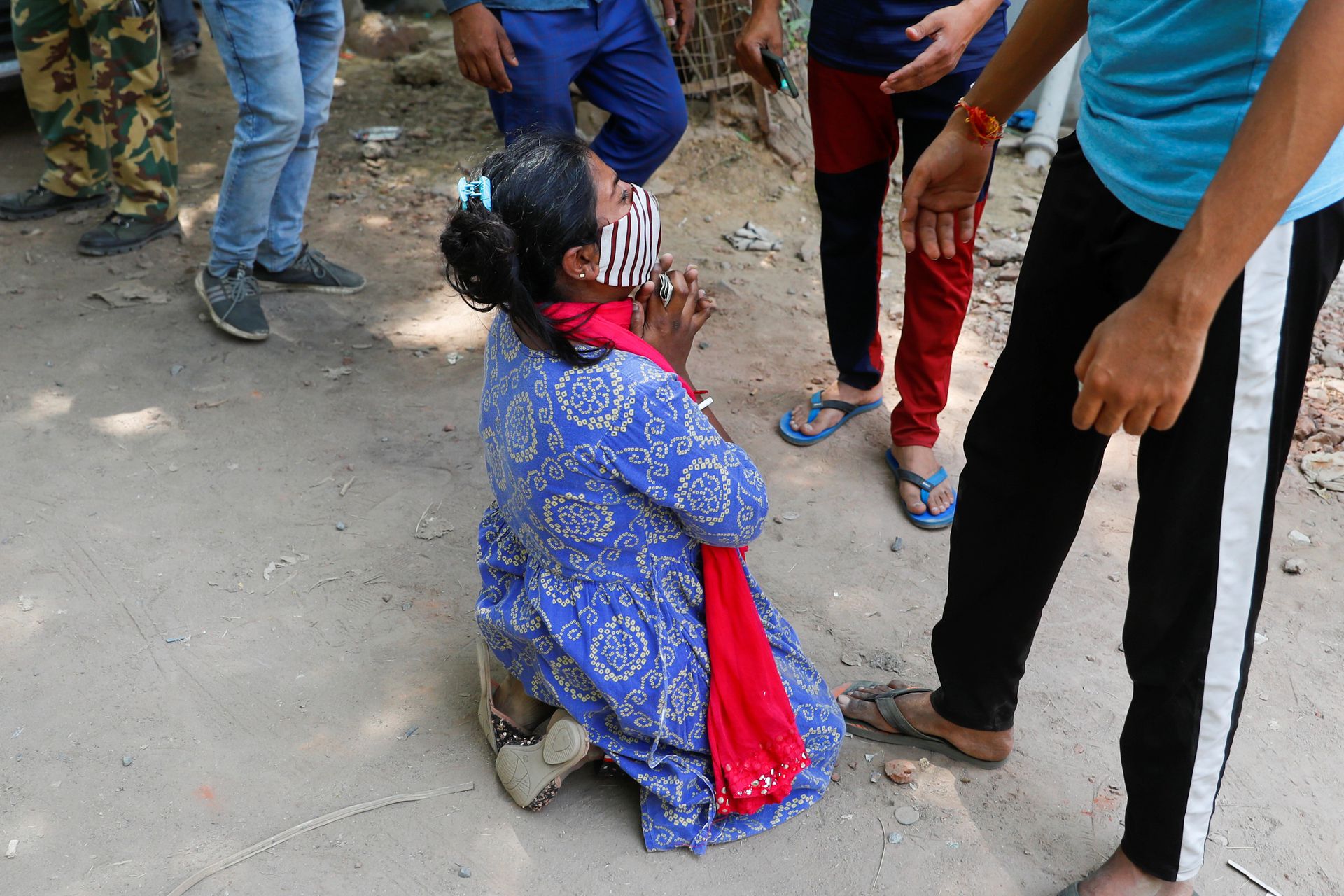 ये तस्वीर बीते 28 अप्रैल की है. दिल्ली में एक रिफिलिंग सेंटर के बाहर अपनी मां के लिए श्रुति साहा 27 अप्रैल से ऑक्सीजन सिलेंडर भरने का इंतजार कर रही थीं. इसी दौरान उन्हें अपनी मां के निधन का समाचार मिला तो वो जमीन पर बैठकर रोने लगीं. (फोटो: रॉयटर्स)