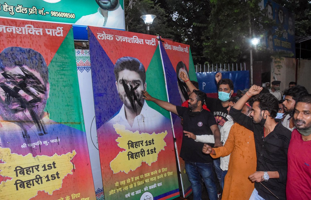 बीते मंगलवार को बिहार की राजधानी पटना स्थित लोजपा के दफ्तर के बाहर पशुपति कुमार पारस सहित पार्टी के अन्य बागी सांसदों के पोस्टरों पर काला पेंट पोतते चिराग पासवान के समर्थक. (फोटो: पीटीआई)