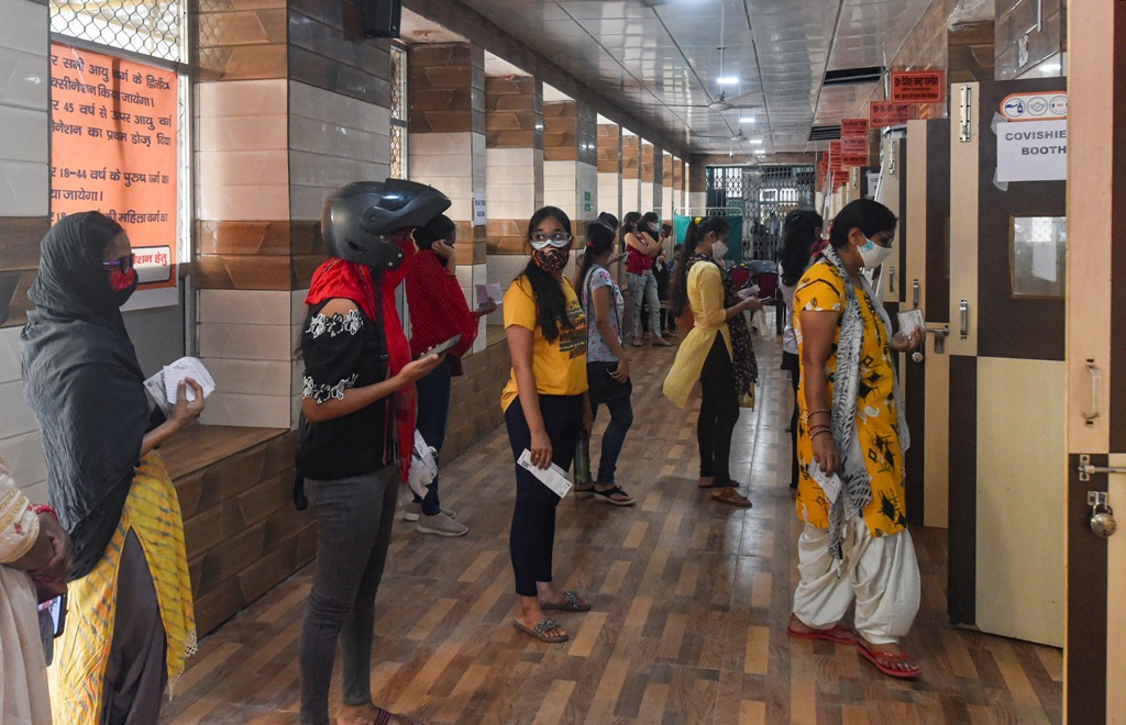 उत्तर प्रदेश की राजधानी लखनऊ के एक सिविल अस्पताल में कोविड-19 रोधी टीके के लिए लाइन में लगे लोग. (फोटो: पीटीआई)