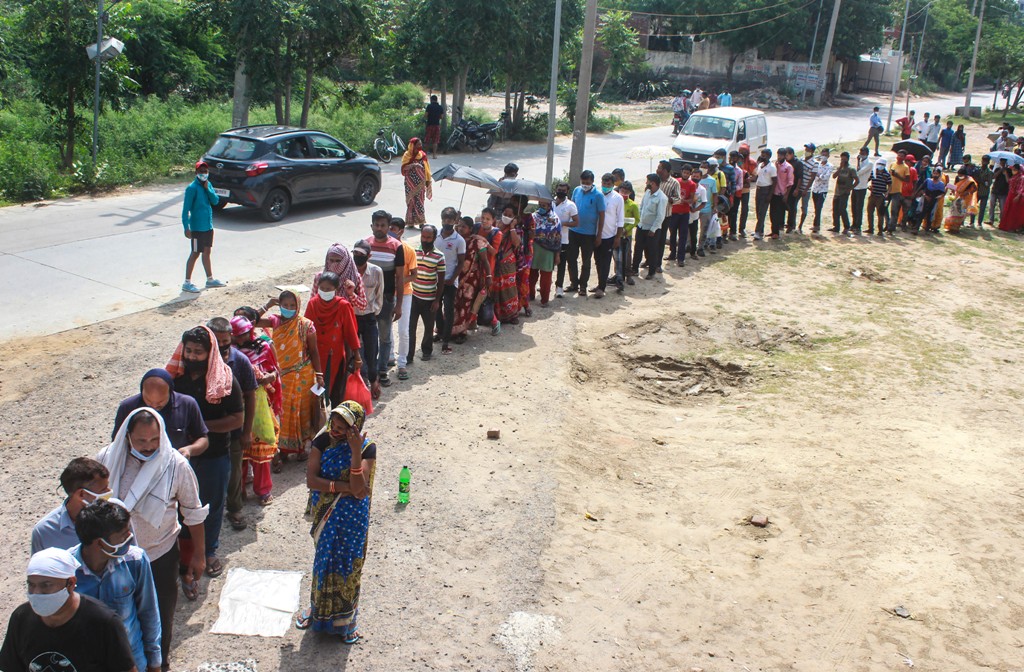 गुड़गांव के फाजिलपुर गांव में एक टीकाकरण केंद्र के बाहर टीका लगवाने के लिए लाइन में लगे लोग. (फोटो: पीटीआई)